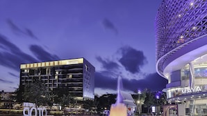 Un edificio moderno con un llamativo letrero 'EASTIN', una fuente y una estructura de diseño único con un patrón esférico.