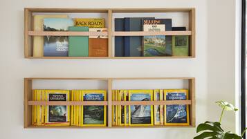 Twee houten boekenplanken vol boeken en tijdschriften.
