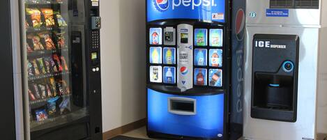 Una máquina expendedora con el logotipo de Pepsi, una máquina de aperitivos y un dispensador de hielo.