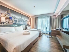 Habitación de hotel con dos camas, un escritorio, una silla, un televisor y un mural grande de un templo.