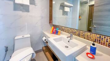 A modern bathroom with a toilet, sink, and mirror.