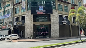 Un hotel con un cartel llamativo que dice 'HOTEL', un cartel de BestView Hotel y varias ventanas.