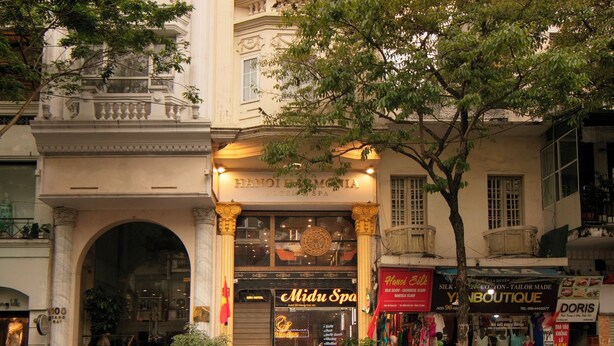 A multi-story hotel with a classic architectural style, featuring a prominent entrance with steps and a large arched doorway. - Hanoi Harmonia Hotel & Spa (Hanoi)