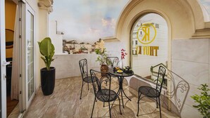 A balcony with a table and chairs, a potted plant, and a view of the cityscape. - Hanoi Harmonia Hotel & Spa (Hanoi)