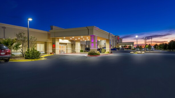 A hotel with a modern design, featuring a well-lit entrance and a parking area. - Red Roof Inn Pecos (Pecos)