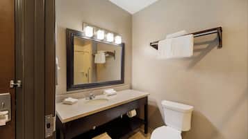 A bathroom with a sink, mirror, towel rack, and toilet.