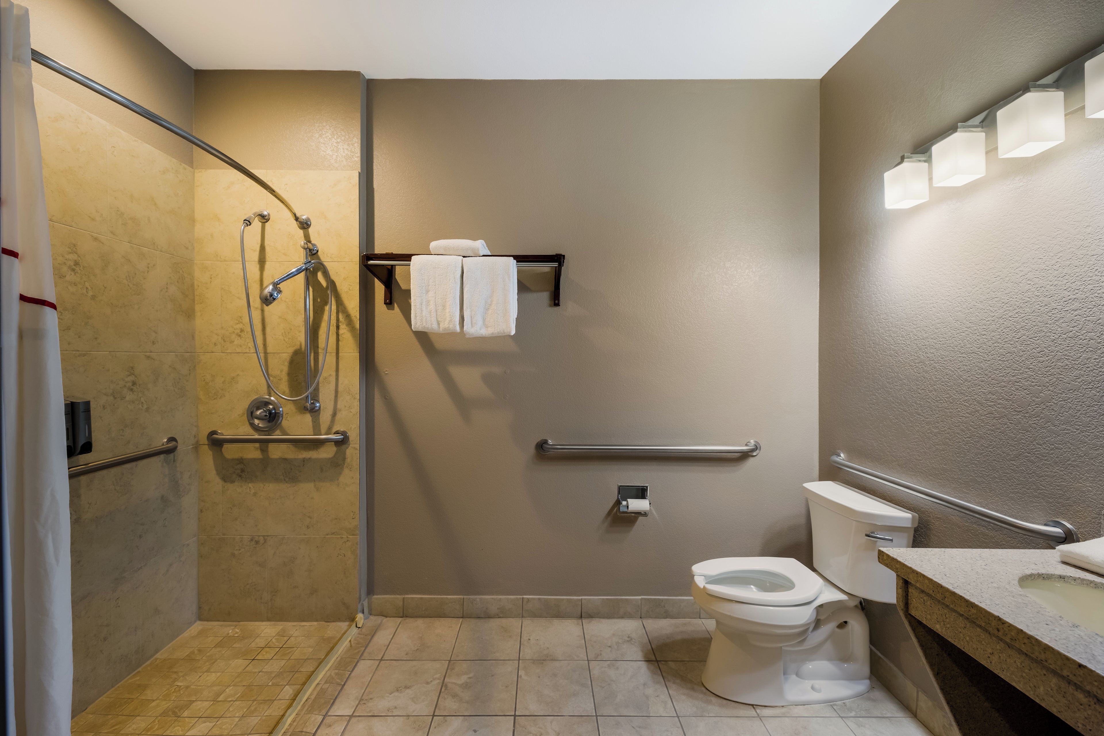 A bathroom with a shower, toilet, and sink.