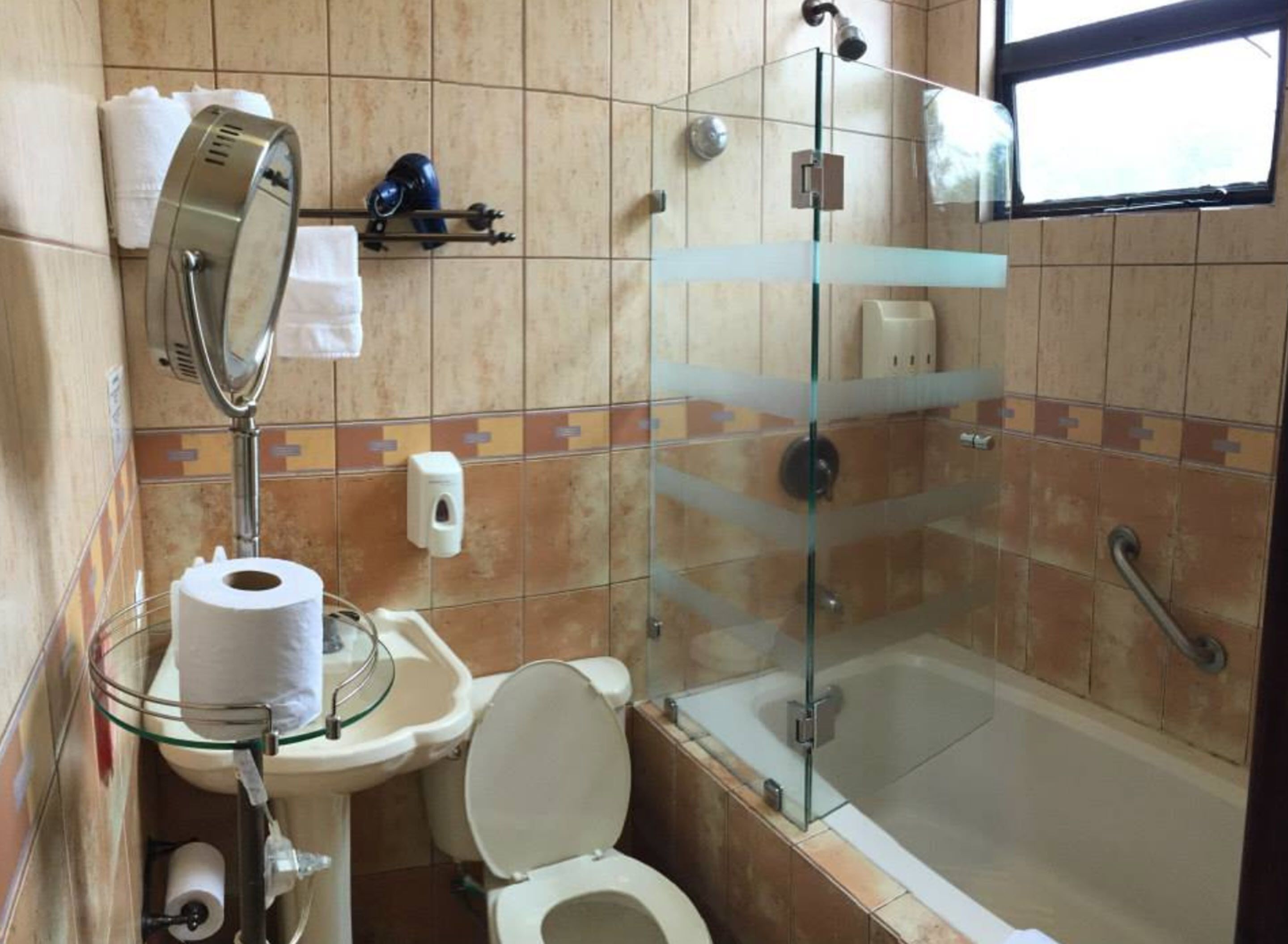 Une salle de bain avec une douche à parois de verre, des toilettes et un lavabo.