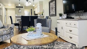 A cozy living room with a round coffee table, a sofa, and a TV. There's a kitchen in the background and a sign that says "Wi-Fi". - 2 UNITS, Ground Floor, Branson's Pointe Royale, INDOOR POOL, Golf, Sleeps 12 (Branson)