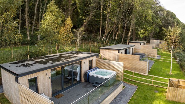 A modern wooden cabin with a glass-enclosed hot tub and a deck. - Caswell Bay Hide Out - Cabin - Landimore (Swansea)