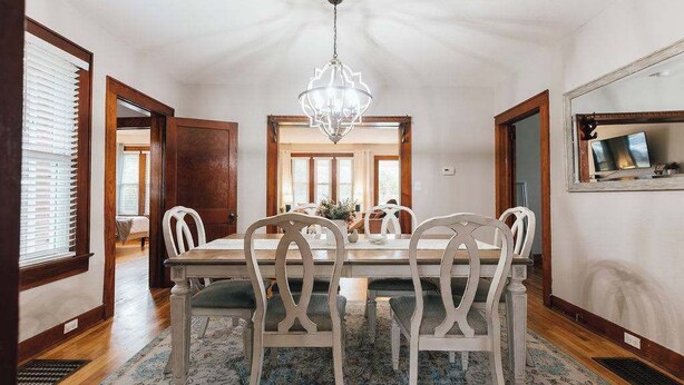 Comedor con candelabro, mesa de madera y sillas.