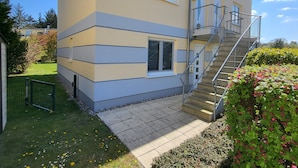 A two-story building with a modern design, featuring a staircase with metal railings leading to the upper floor. - Cozy vacation apartment in the countryside with garden and terrace (Gelbensande)