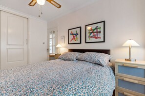 A bedroom with a bed, two wall-mounted lamps, and two framed abstract artworks. - On The Beach - Direct Beach Access, Sea Views (Saundersfoot)
