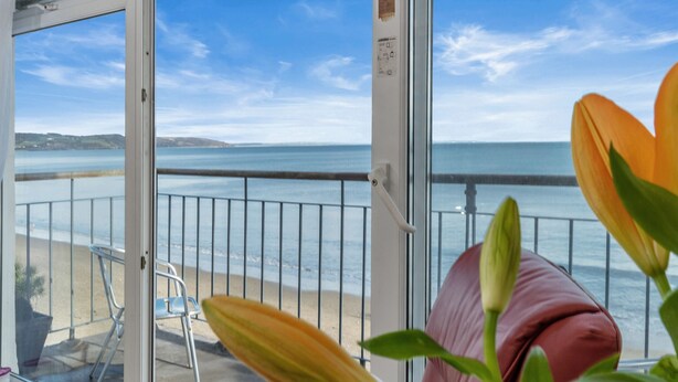 A balcony with a view of the sea, a chair, and a potted plant. - On The Beach - Direct Beach Access, Sea Views (Saundersfoot)