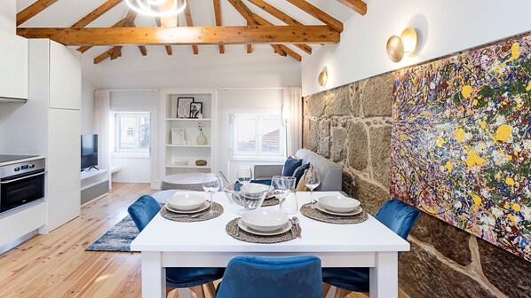 A dining area with a white table set for four, surrounded by blue chairs.