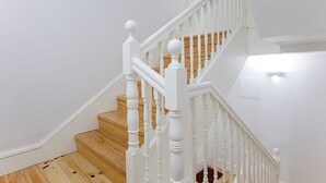Un escalier avec des balustrades blanches et des marches en bois.