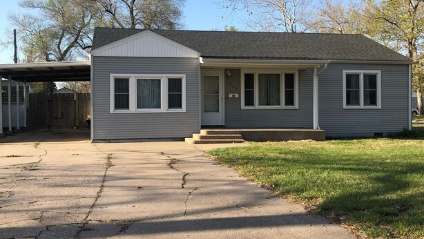A single-story house with a front yard, a driveway, and a garage.