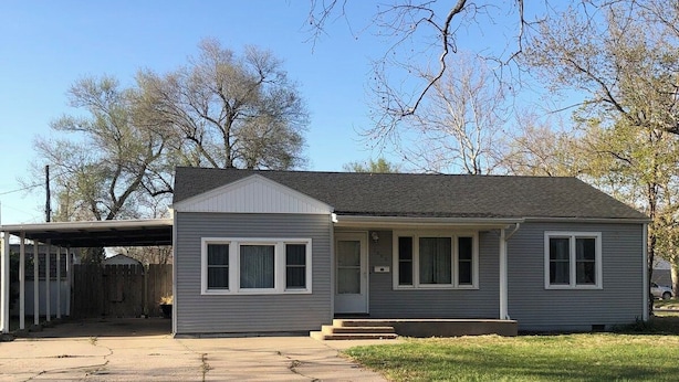 Una casa a un piano con un portico anteriore, un garage e una zona patio coperta.