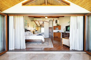 A spacious bedroom with a large bed, a wooden ceiling, and a view through a sliding glass door. - Stay 17 - Playa Flamingo Beachfront Villa at The Palms (Playa Flamingo)