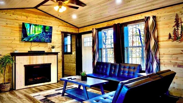 A cozy living room with a fireplace, a television mounted on the wall, and a comfortable seating area.