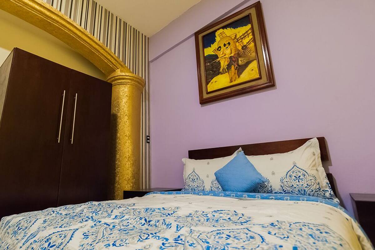 Ein Schlafzimmer mit einem Bett, einem Kleiderschrank und einem Bild an der Wand.