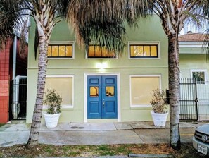 Stylish two-story building with a blue door and white-framed windows, featuring a simple architectural style and a flat roof.