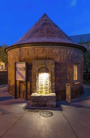 Explore a historic building with a conical roof and a central stone fountain.