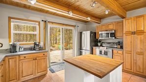A modern kitchen with wooden cabinets, stainless steel appliances, and a large island.
