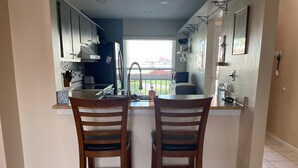 A kitchen with two wooden chairs, a window, and a sink. - On the water and golf course view (St. Petersburg)