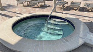 A hot tub with a tiled edge, surrounded by a brick patio. - On the water and golf course view (St. Petersburg)