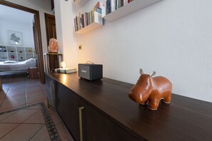 A hotel reception area with a wooden counter, a salt lamp, a radio, and a leather elephant decoration.
