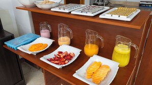 A breakfast buffet with various fruits, juices, and pastries. - kAPAC INN HOTEL (Cusco)