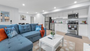 A modern apartment with a living room, kitchenette, and a dining area.