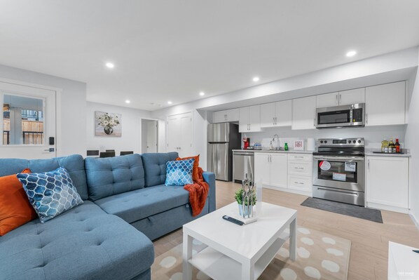 Ein modernes Apartment mit Wohnzimmer, Küchenzeile und Essbereich.