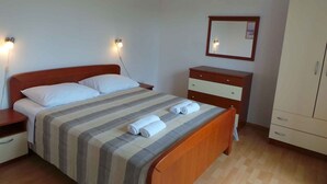 A bedroom with a bed, bedside tables, a dresser, a mirror, and a wardrobe. - Apartment in Ljubač with Seaview, Balcony, Air condition, WIFI (809-3) (Ljubac)
