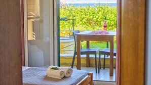 Une chambre avec un lit, une fenêtre et une vue sur un jardin et des montagnes.