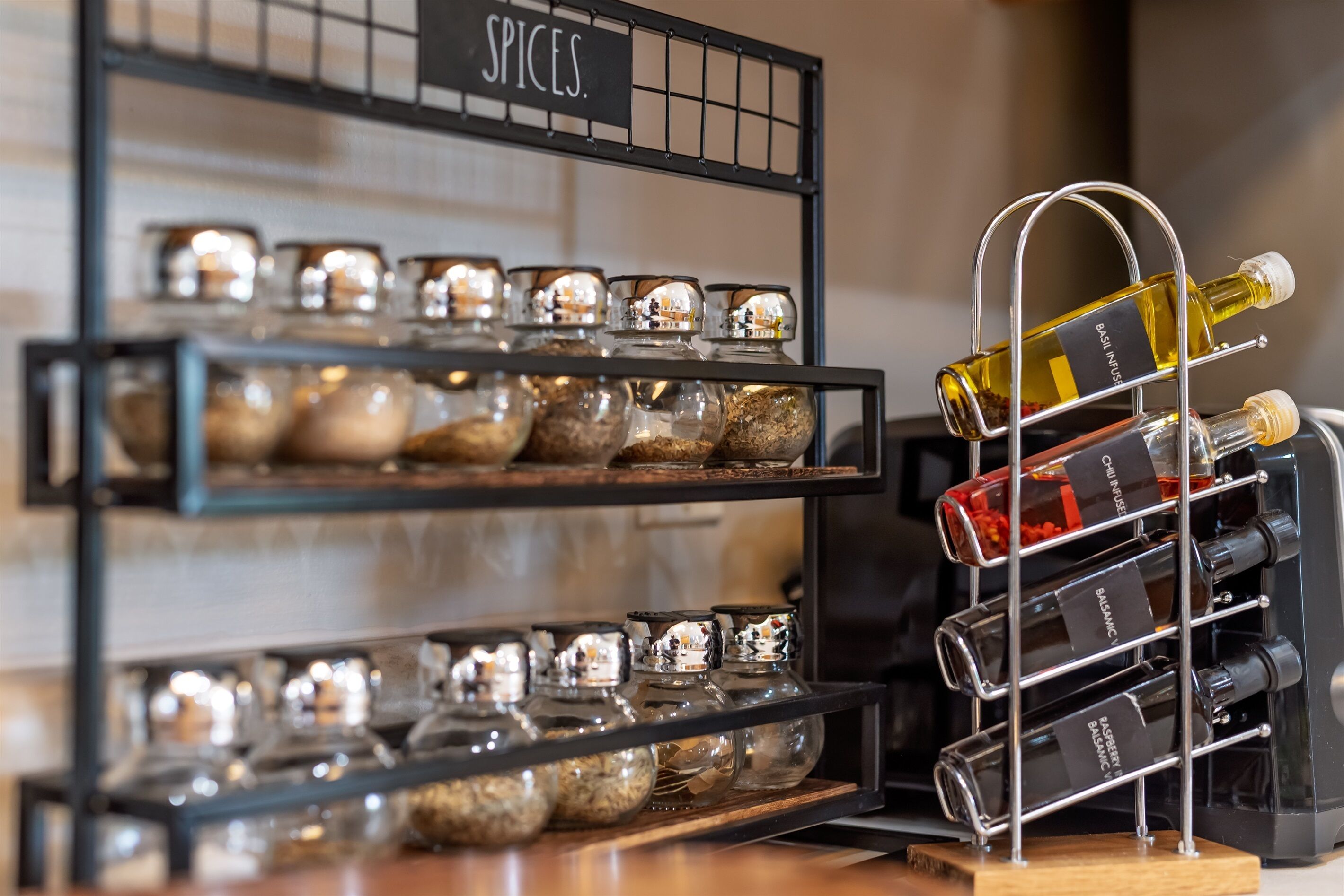A rack with jars of spices and bottles of wine.