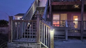 Une maison en bois à deux étages, avec un escalier menant à un balcon.