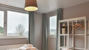 Un dormitorio con dos camas, un armario y una ventana con cortinas.