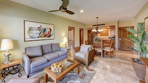 A living room with a sofa, coffee table, and a dining area with chairs.