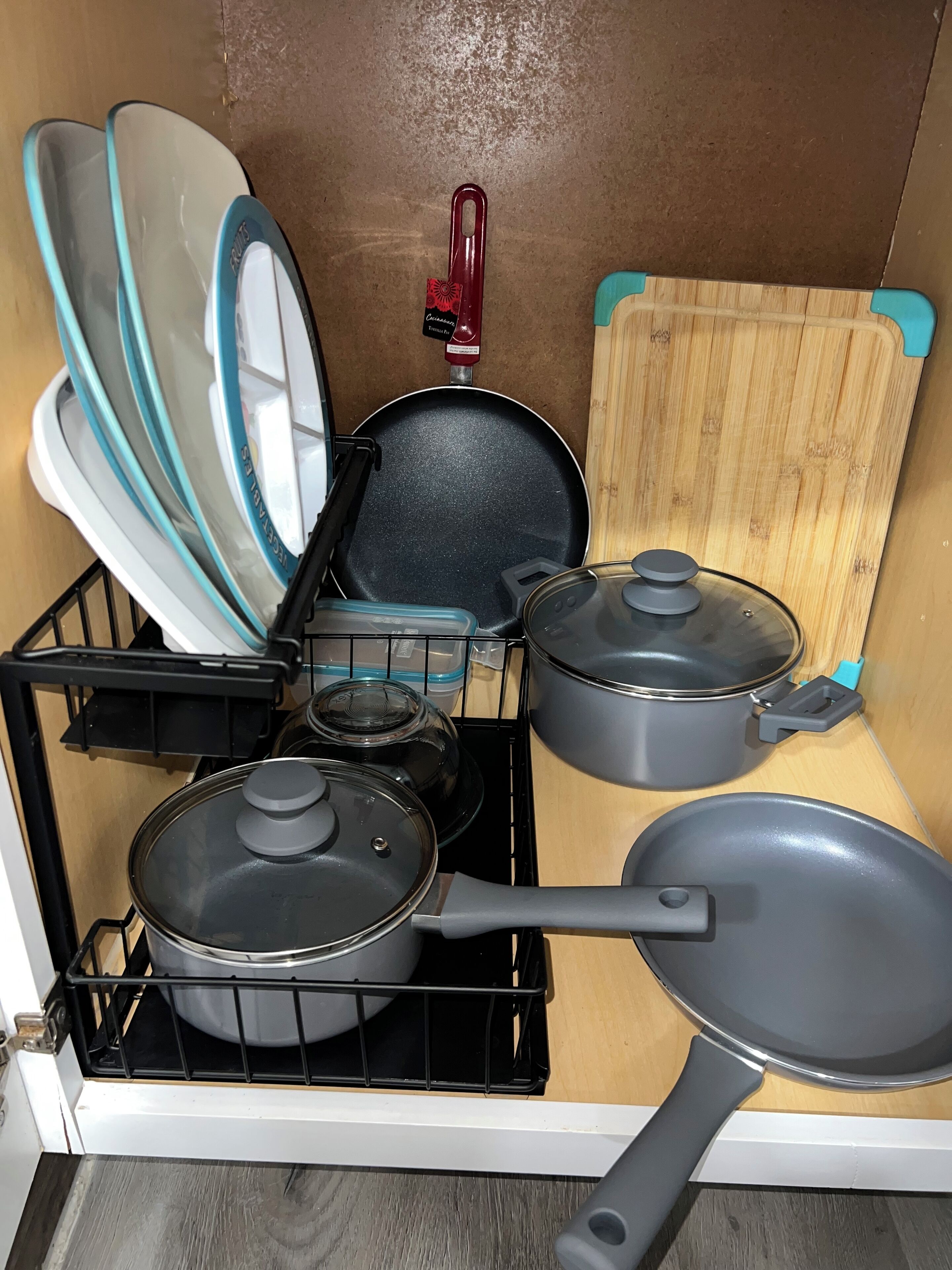 Une cuisine équipée d’une cuisinière, de casseroles, de poêles et d’une planche à découper.