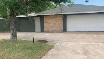 A residential garage with a brick facade and a white garage door.