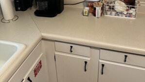 A kitchen with white cabinets, a coffee maker, a toaster, and a container with utensils. - Five Points neighbor. Located 1.4 from UGA stadium. (Athens)