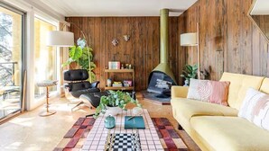 A modern living room with a fireplace, leather furniture, and a large window. - Downtown Mid-Century Modern Condo with Retro Vibes (Boise)