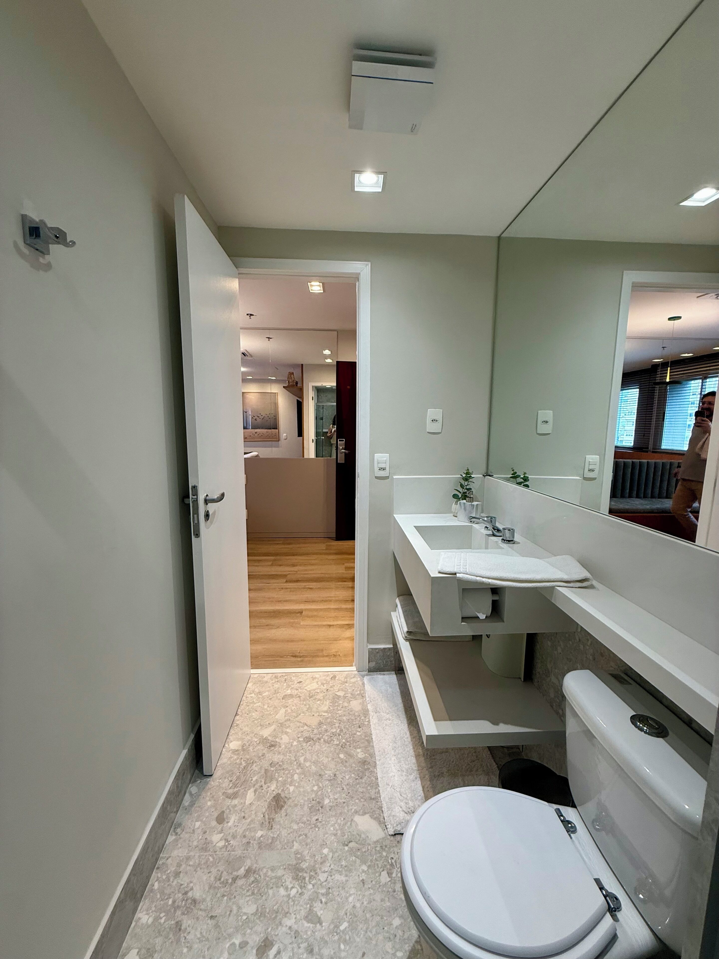 A modern bathroom with a toilet, sink, and mirror.