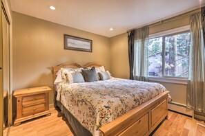 A bedroom with a wooden bed, a nightstand, a framed picture on the wall, and a window with curtains. - 3 Mi to Skiing! Incline Village Retreat w/ Sauna (Incline Village)
