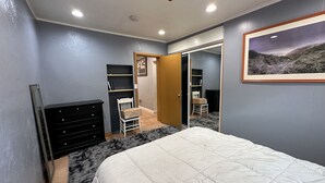 Ein Schlafzimmer mit einem Bett, einem Schminktisch und einer Tür zu einem Kleiderschrank.