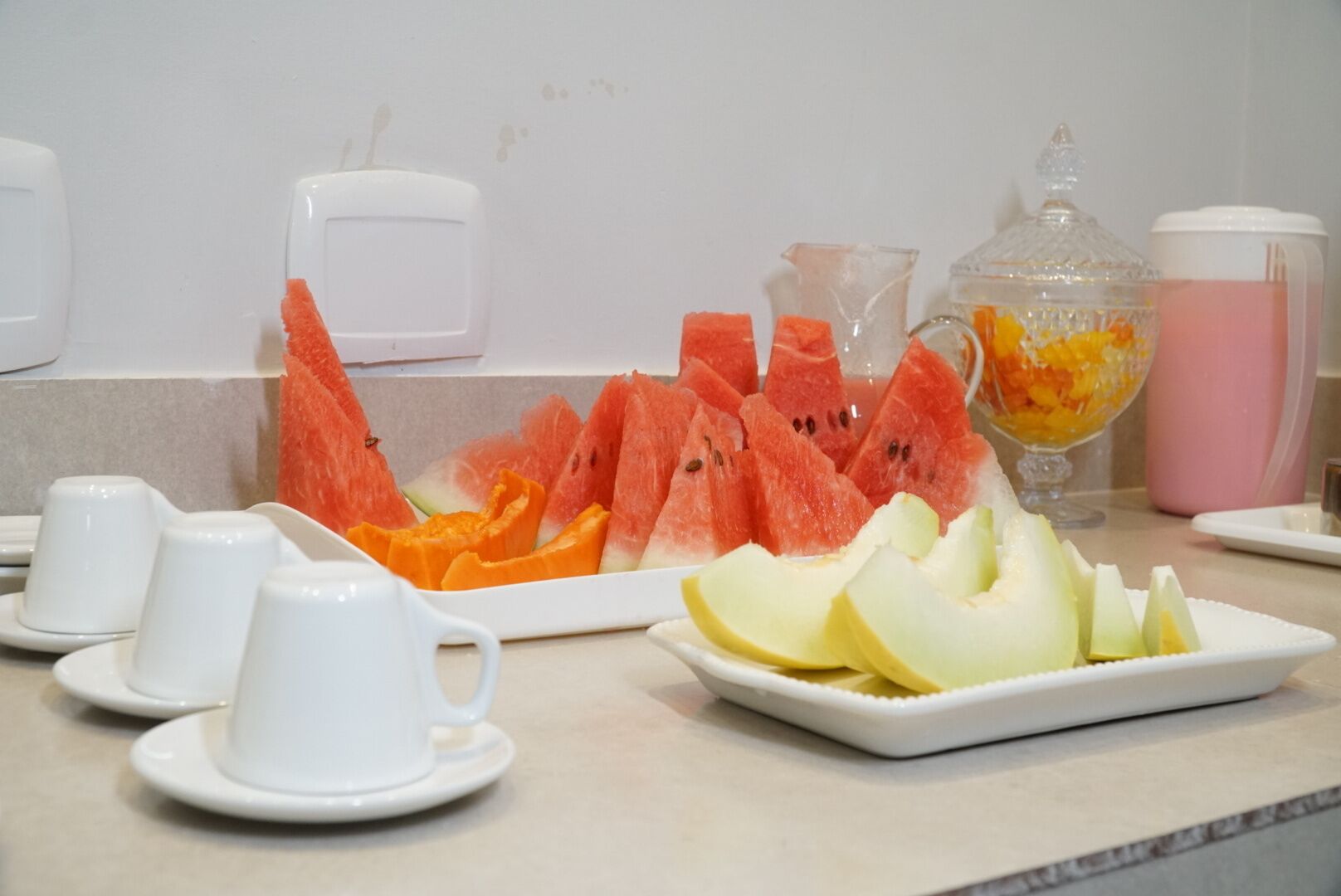 A breakfast buffet with watermelon, cantaloupe, and orange slices.