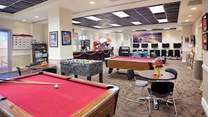 Un espacio recreativo con mesas de billar, futbolín y billares.
