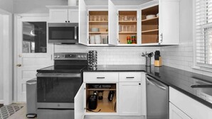 A modern kitchen with white cabinets, a built-in oven, and a microwave. - Cozy KC Suburb Home, Sleeps8_ PoolTable_ Foosbal (Mission)